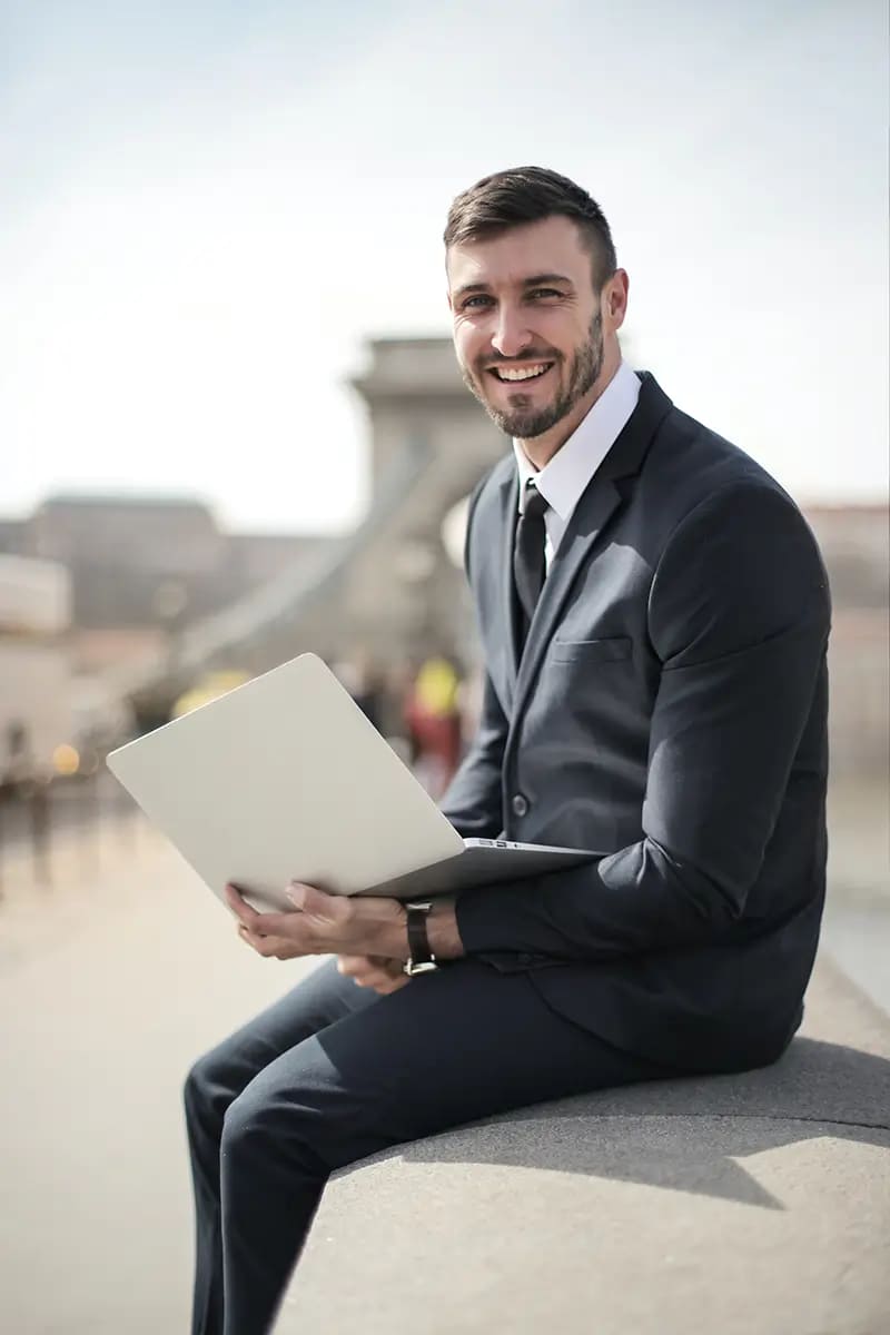businessman smiling with a laptop on hand